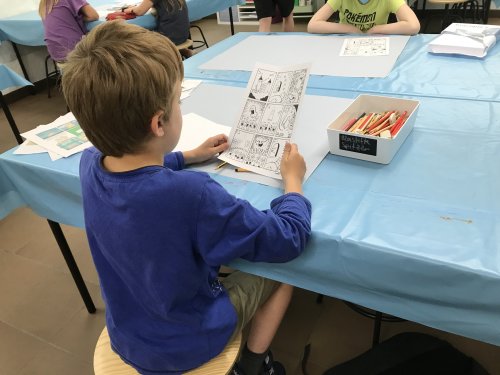 Der neunjährige Henri schaut sich eine Comic-Vorlage von Christoph Jansen an, um so Anregungen für seine eigene Bildergeschichte zu bekommen. (Foto: OBK)
